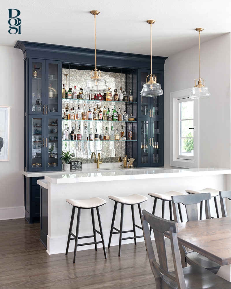 wet bar with navy blue cabinetry with a white marble counter and white barstools