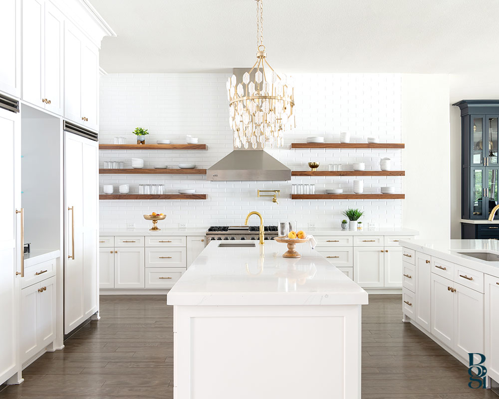 remodeled kitchen in trending white cupboards and natural wood shelves and gold accented lighting