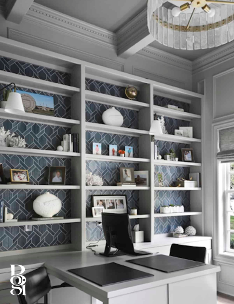 a fully shelved wall with wallpaper insets behind a modern office with built in desk