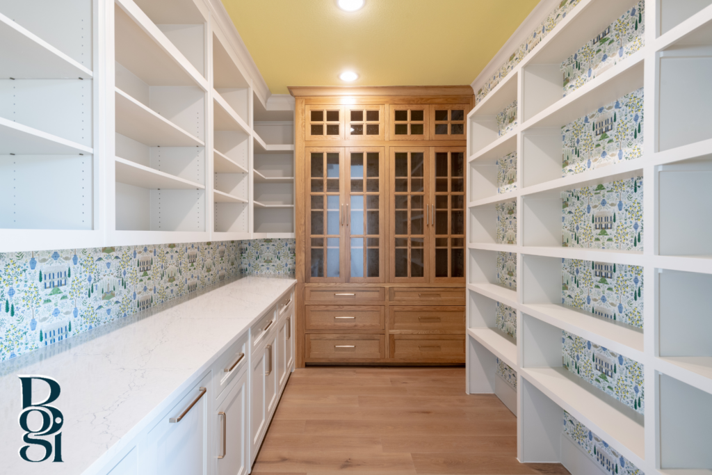 modern pantry with white cabinetry and trending wallpaper behind